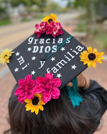 A photo of a graduation cap, which reads, "Gracias Dios y mi familia." Translation: "Thank you God and my family."